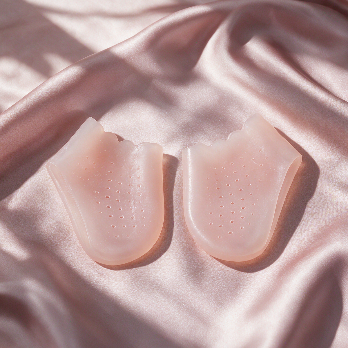 Paire de protège-talons en gel silicone SÉVANE rose poudré sur une soie rose